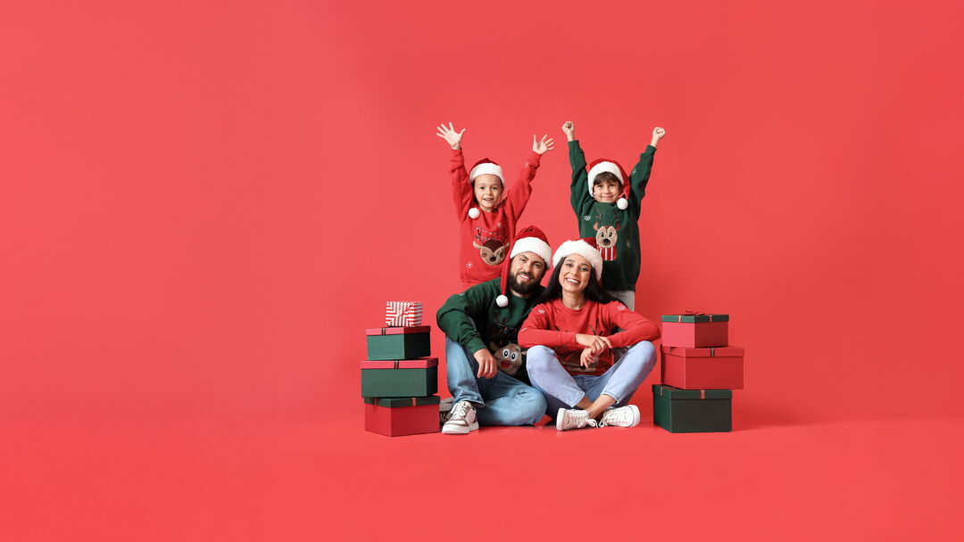 Familie in Weihnachtskleidung mit Geschenken