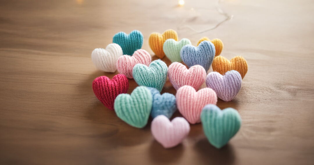 Gestrickte Herzen auf Holztisch
