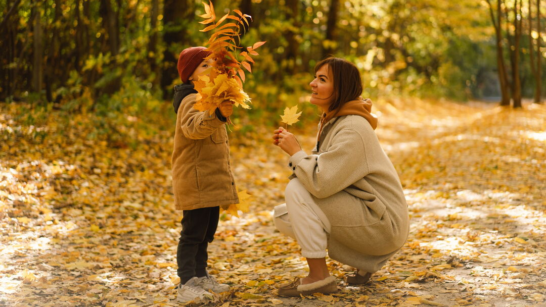 Frau mit Kind im herbstlichen Wald